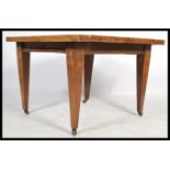 An Edwardian Arts & Crafts oak wind out extending dining table complete with winder and additional