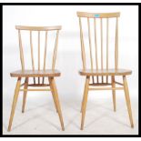 An Ercol beech and elm high back spindle back dining chair along with a near matching smaller