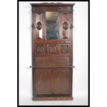 An early 20th century Edwardian oak wall mounted hall stand, having bevelled mirror inset, panel