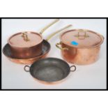Two vintage 20th century copper sauce pans, both with fitted lids with hoop handles atop together