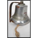 A vintage 20th century polished steel and bronze wall mounted bell of large form complete with