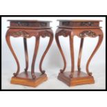 A pair of Chinese hard wood pedestals each with solid tops above carved blossoming aprons and on