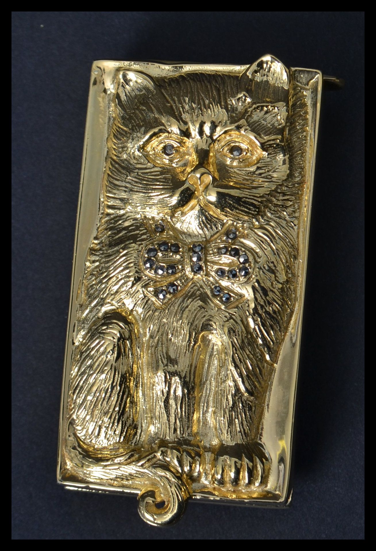 A gilt silver vesta case in the form of a cat with marcasite bow and eyes. Weighs 60.5 grams.