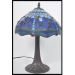 A vintage Tiffany style leaded glass table lamp having a naturalistic style base with stained