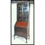 A 1920's mahogany bureau bookcase having an astragal glazed door bookcase over a fall front bureau