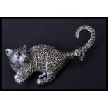 A sterling silver and marcasite brooch in the form of a cat with ruby eye. Pin to verso. Weighs 18.6