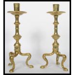 A pair of 19th century Victorian brass candlesticks raised on tripod hairy paw legs with knopped