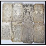 A collection of eight Chinese white metal amulet / scroll weights, cast in relief with various