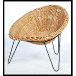 An original retro 20th century whicker tropics chair / armchair raised on a tripod hair pin leg