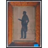 A 19th century Georgian framed and glazed silhouette of a gentleman standing before a balustrade,