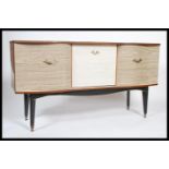 A retro 1970's melamine two one sideboard dresser being raised on tapering legs with drawers and