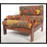 A retro 20th century teak wood show frame armchair being upholstered in a retro floral fabric