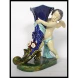 A 19th century Victorian Majolica French cornucopia and cupid vase centrepiece raised on a