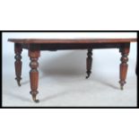 A large mid 19th century Victorian wind out dining table being raised on reeded turned legs with