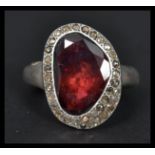 A designer silver and almandine garnet ring having a halo of marcasites. Weighs 20.6 grams size Q.