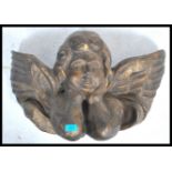 A 20th century papier mache decorative wall handing ornament in the form of a winged cherub angel