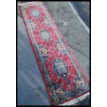 An early 20th century long decorative Persian carpet runner rug having a red ground with geometric