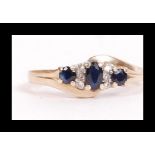 A hallmarked 9ct gold sapphire and diamond crossover ring. Hallmarked London. Weight 3.2g. Size P.