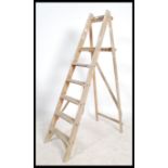 A vintage 20th century Industrial pine wooden step ladder. Of A-frame form having reeded steps and