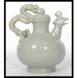 A 20th century Chinese teapot having a green dragon and mythical bird with hole at bottom for