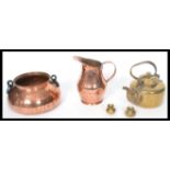An arts and crafts copper hand beaten jug and bowl along with a brass kettle and two miniature brass