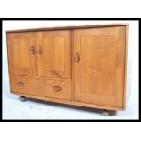 A retro Ercol 20th century elm wood sideboard of small proportions. The sideboard comprising a