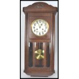 An early 20th century oak cased wall clock. The silvered dial having faceted hands with carved