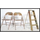 A pair of vintage mid century enamelled metal folding village hall chairs together with a small