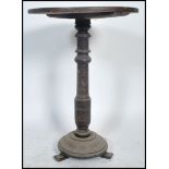 A 19th century Victorian oak wine occasional table raised on three bun feet with turned circular