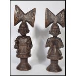 A pair of early 20th century Congo standing fertility figurines of a man and a woman raised on a