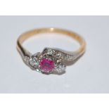 An 18ct gold and platinum ruby diamond ring set with a round cut ruby flanked by two round cut