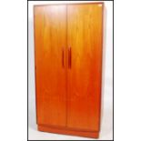 A G-Plan 20th century teak wood double door wardrobe in the ' Kelso ' pattern. Raised on plinth base
