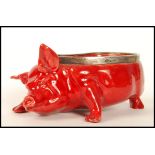 A Royal Doulton red flambe glazed novelty pig, modelled by Charles Noke with silver rim, hallmarks