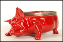 A Royal Doulton red flambe glazed novelty pig, modelled by Charles Noke with silver rim, hallmarks