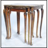 A 20th century trio nest of tables being Japanned and lacquered with gilt borders depicting domestic