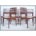 A set of 20th century retro teak wood stained dining chairs complete with the 2 carvers. Railed