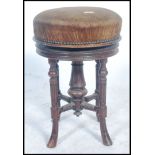 A Victorian 19th century aesthetic movement mahogany circular revolving piano stool. The pad seat