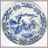 An early 19th century Chinese blue and white cabinet plate depicting fighting warriors and