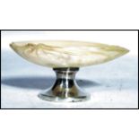 A silver hallmarked and mother of pearl table salt raised on a circular silver base with mother of