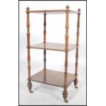 A Victorian walnut 3 tier etargere / whatnot being raised on cup and cover legs with brass cap