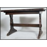 A 1930's oak draw leaf refectory dining table being raised on lyre shaped supports with stretcher