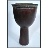 A 20th century side table in the form of a tribal drum with a brass Anglo Indian top. Measures