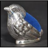 A sterling silver pin cushion in the form of a bird with blue baize cushion atop. In the manner of