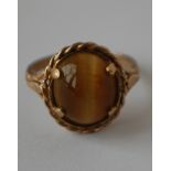 A hallmarked 9ct gold ring set with a tigers eye cabochon.  Hallmarked London.  Size L. Weight 3.3g.