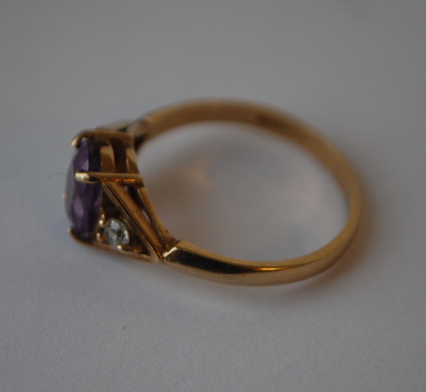 A hallmarked 9ct gold three stone ring set with a central oval cut purple stone flanked by two white - Image 2 of 3