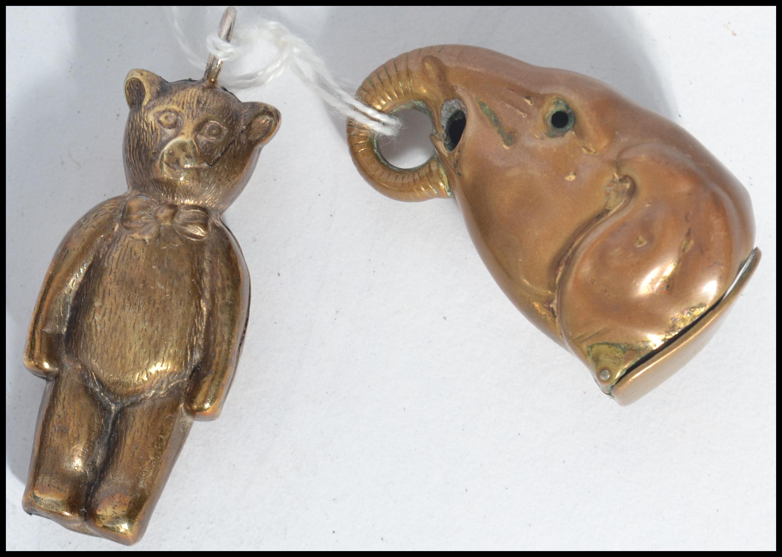 Two vintage brass novelty items one being a baby's rattle in the form of a teddy bear , and the