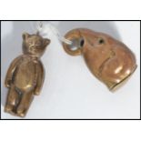 Two vintage brass novelty items one being a baby's rattle in the form of a teddy bear , and the