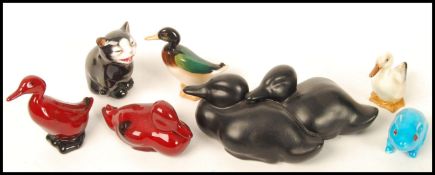 A group of Royal Doulton animals to include two Flambe duck a black cat , a black duck figurine