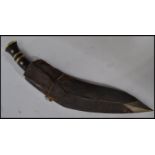 A 20th century brass and white metal inlaid kukrie knife with velvet lined scabbard, the handle with