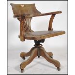 An early 20th century / circa 1920's industrial mahogany swivel office desk chair having a fan